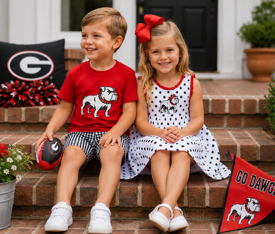 Boy and girl siblings in matching Georgia Bulldogs outfits sitting on brick steps at Palmetto Kids Boutique