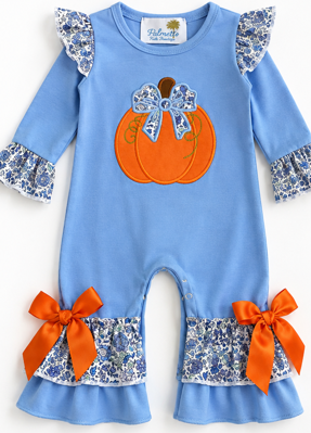 A baby long-sleeve romper in light blue, decorated with a large orange pumpkin applique on the chest, blue floral ruffle cuffs, orange satin bows at the ankles, and a floral neck label.