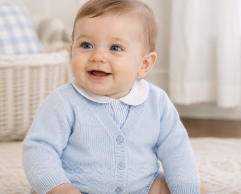 Baby boy wearing a classic light blue knit cardigan layered over a boutique bubble outfit for church.
