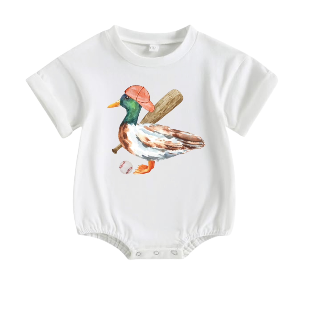White baby boy bubble romper featuring a watercolor mallard duck wearing a baseball cap and carrying a baseball bat by Palmetto Kids Boutique.