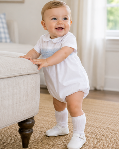 Little boy wearing a Petit Ami white hand-smocked bubble for church and family portraits.